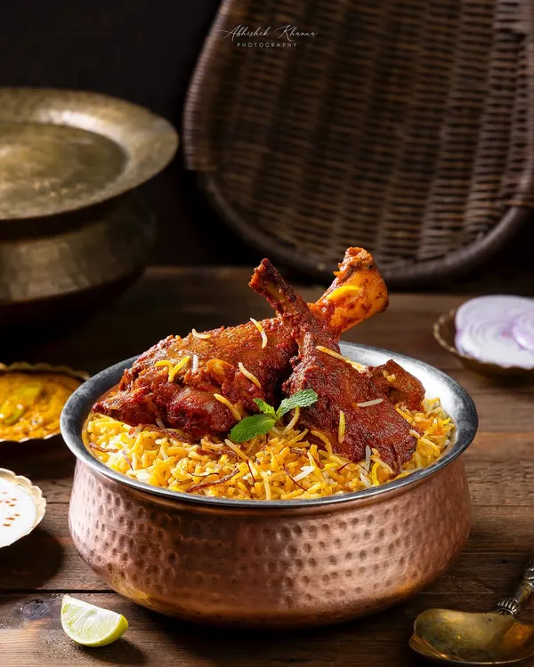 A Hyderabadi chicken biryani, styled with traditional copper and brass serveware for The Nawaab’s. The lighting is crafted to highlight the texture of the rice and the rich color of the chicken.