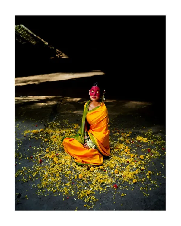 An artistic interpretation of the Haldi ceremony. The dramatic lighting, vibrant yellow saree, and scattered flowers create a powerful, conceptual image that tells a cultural story.