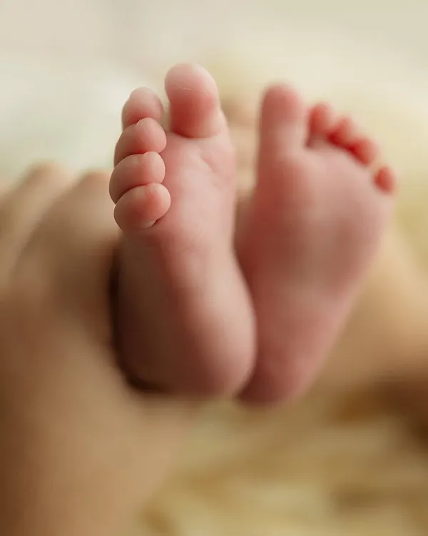 Two tiny feet, held gently in a parent's hands. This shot is a powerful reminder of how small and precious they are in these first few weeks.