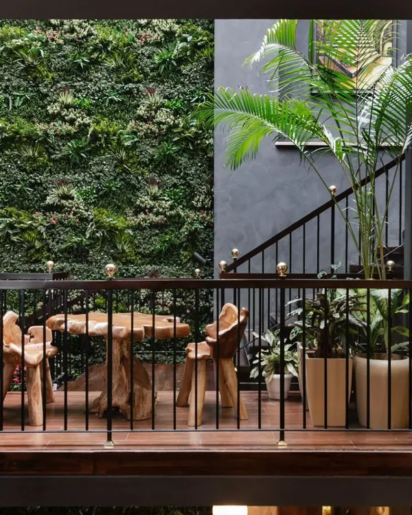A hanging garden on the staircase landing of our Utopia project, set against a lush vertical garden wall. This is a core example of our biophilic approach, transforming a transitional space into a living, breathing part of the home.