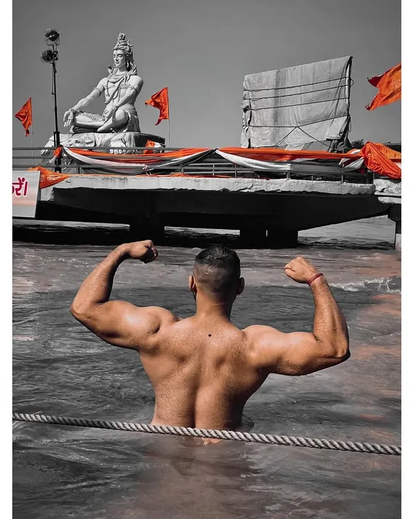 Strength and devotion in one frame. Flexing my back in the holy Ganga river with the iconic Shiva statue of Rishikesh in the background.