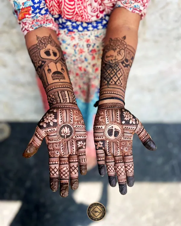A beautiful and intricate baby shower henna design. We included a lotus on one palm and baby feet on the other, along with personalized elements on the arms to celebrate the occasion.