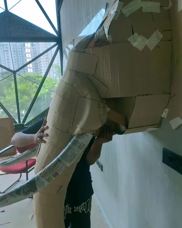 This is how the giant cardboard elephant head began. Our team is seen here shaping and taping individual pieces of cardboard to build the complex structure before the final details were added.