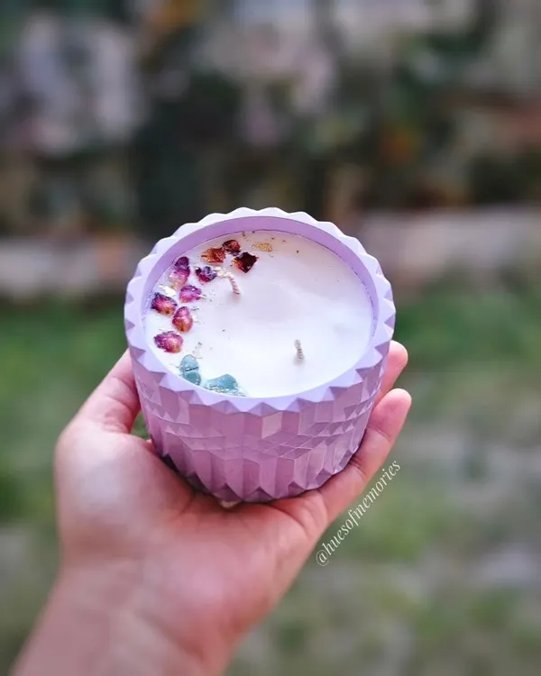 A close-up of my largest candle, featuring a beautiful lavender eco-resin jar with a diamond pattern. The soy wax is topped with dried rose petals and crystals for an extra touch of elegance.
