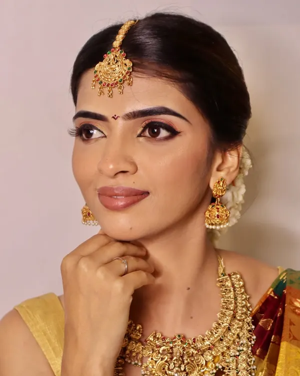 A close-up of a classic South Indian bridal look created by our students, focusing on achieving a radiant base, sharp winged eyeliner, and perfectly defined brows to complement traditional gold jewelry.