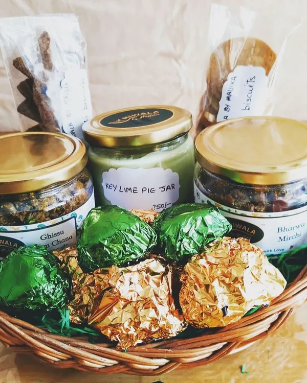 A look inside one of my custom gourmet gift hampers. This one features my best-selling Ghissu Aam Chana and Bharwa Mirchi pickles, homemade ragi and atta biscuits, a jar of my special Key Lime Pie dessert, and some assorted chocolates, all nestled in a reusable basket.