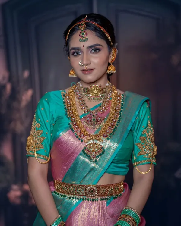 A complete South Indian bridal jewellery set featuring layered necklaces, a goddess-pendant choker, and matching jhumkas. This rental set provides a grand and traditional look.