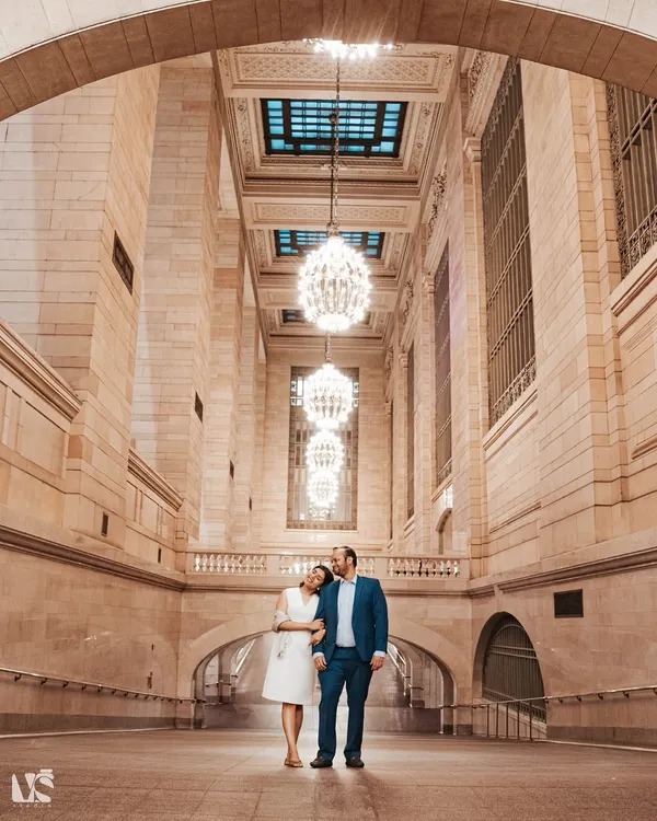 A stunning portrait of a couple standing in New York's Grand Central Station. The grand architecture and beautiful chandeliers create a timeless and sophisticated backdrop for their urban love story.