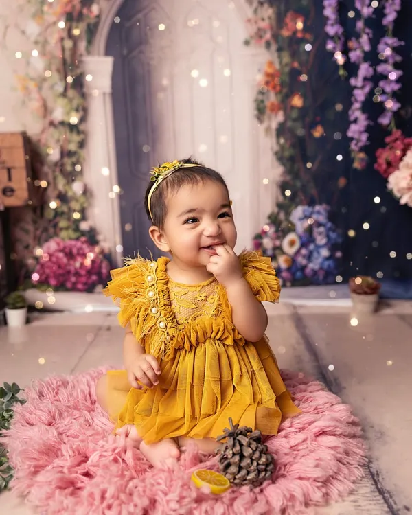 This is what pure sunshine looks like. I designed this whimsical floral wonderland in my studio to capture this little one's magical smile and create a truly timeless portrait.