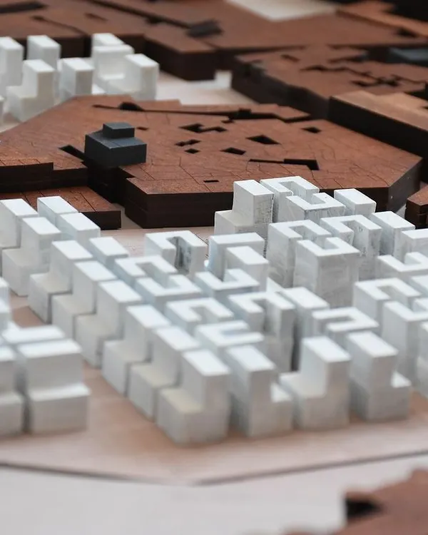This urban massing model, crafted from wood, helps us understand the relationship between existing structures and new interventions. It is a tool for studying density, scale, and the creation of public space at a city level.