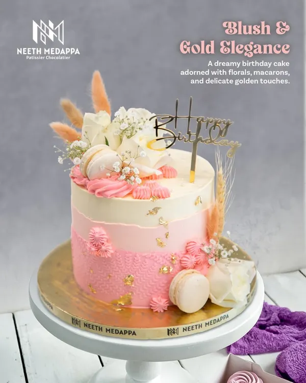 Blush and Gold Elegance. This dreamy birthday cake is adorned with fresh florals, delicate macarons, and touches of gold leaf for a soft, romantic feel.
