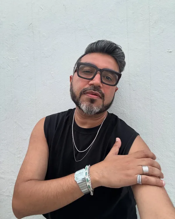 A close-up of my Mykonos look. The focus is on the accessories: layered silver chains, a statement watch, and bold rings that add a personal edge to a simple black outfit.