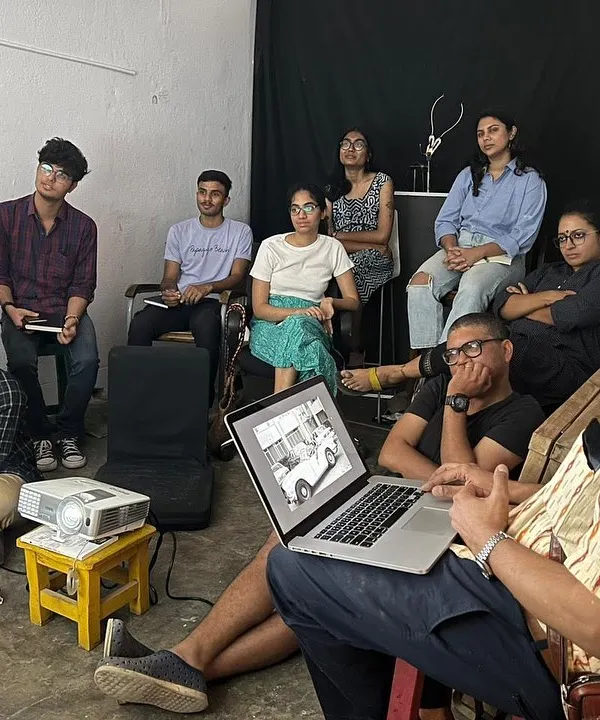 Participants in a photography project listen intently during a presentation. Our studio is equipped with a projector, making it a great spot for educational talks, critiques, and film screenings.