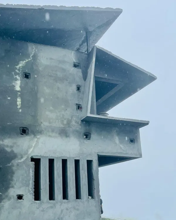 The exterior of our 'Panorama' project in Ooty, showing its angular concrete forms taking shape against the misty climate. The design features deep overhangs and carefully placed openings, characteristic of modern contextual architecture.