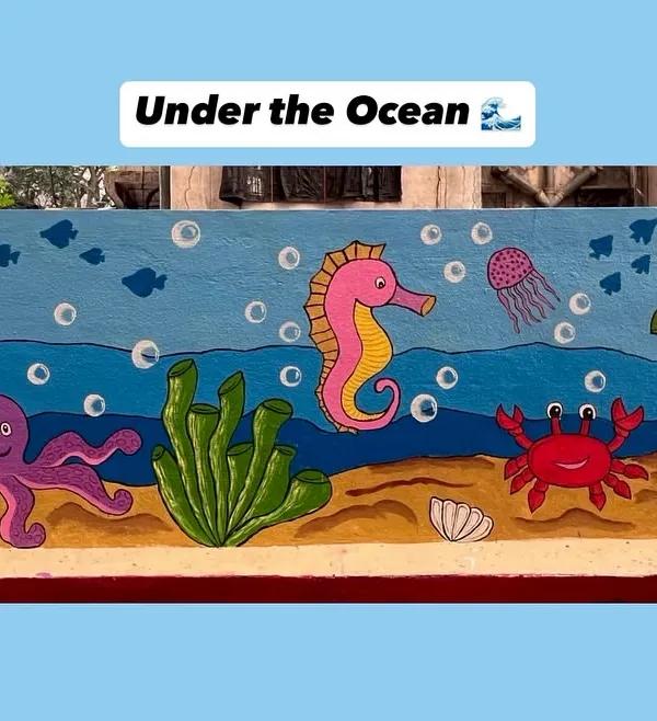 This cheerful underwater mural transforms a plain wall into an aquatic adventure, complete with a friendly crab, jellyfish, turtle, and seahorse.