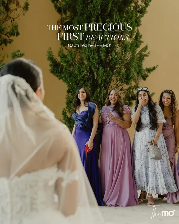 The most precious first reactions. This shot captures the pure, unscripted joy and surprise on the faces of bridesmaids as they see the bride for the first time, a moment of genuine emotion and friendship.