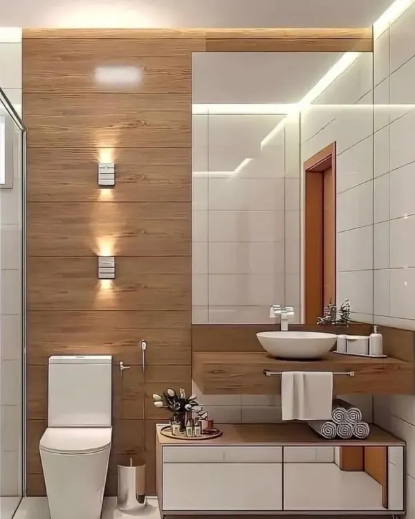 An elegant and warm bathroom design. The combination of wood-paneled walls, white tiles, and smart lighting creates a spa-like feel. The floating vanity adds to the modern look.