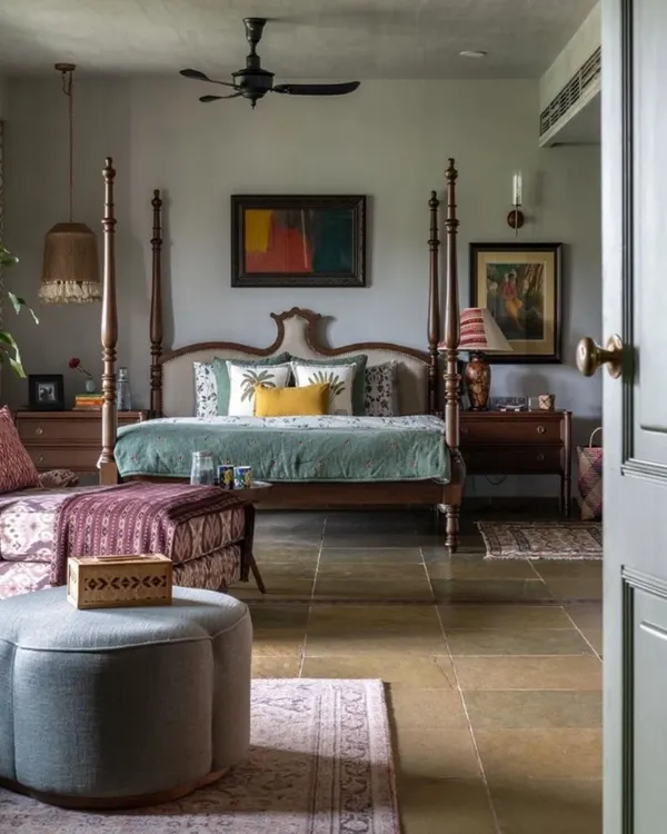 This bedroom in a Dhaka residence is a perfect example of a cultured, cozy retreat. A classic four-poster bed is the centerpiece, complemented by custom furniture and art sourced from around the world. The stone flooring and soft lighting create a humble yet elegant vibe.