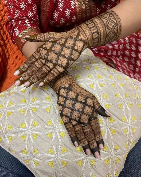 This design is a masterpiece of traditional patterns. The hands are covered in a dense lotus jaal (net), which requires a very steady hand and creates a stunning, textured look once the stain develops.