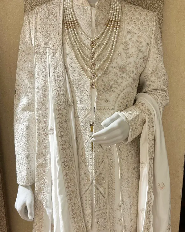 The essence of class is in simplicity and detail. This all-ivory sherwani features tone-on-tone embroidery, paired with a matching stole and a multi-strand pearl necklace for a look of pure elegance.