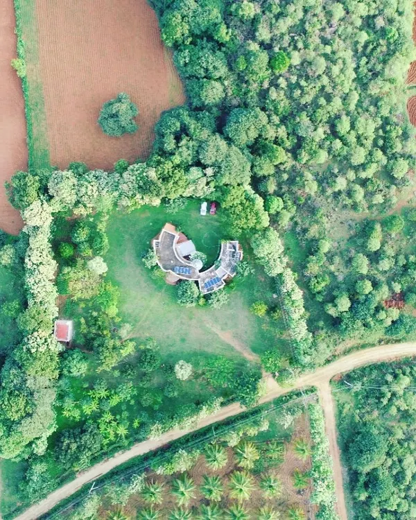 This C-shaped farmhouse is a prime example of innovative design. Its unconventional form is not just for aesthetics; it creates a sheltered central courtyard and maximizes views of the surrounding nature from every room.