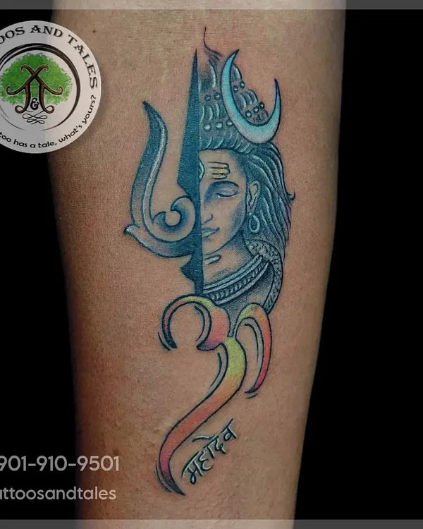 A custom design combining Lord Shiva's face with his Trishul and the Om symbol. We used a mix of blue tones and a gradient of color in the script to give this Mahadev tattoo a unique look.