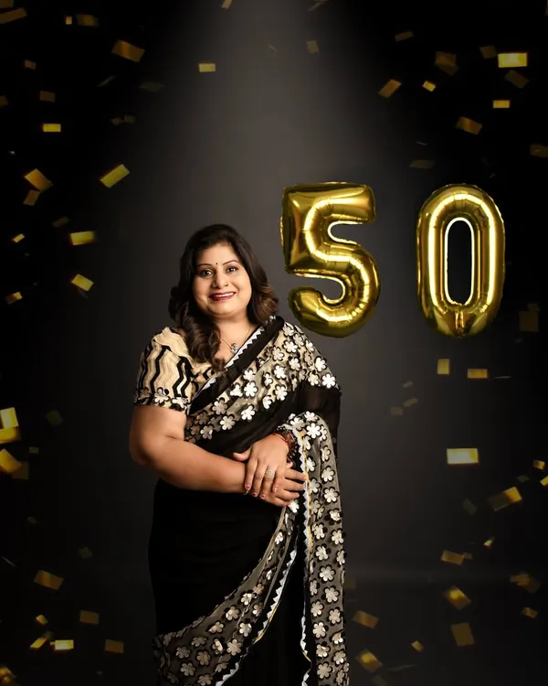 Celebrating 50 years with style and joy. This portrait captures a moment of celebration with golden confetti, marking a golden milestone in a fun and elegant way.
