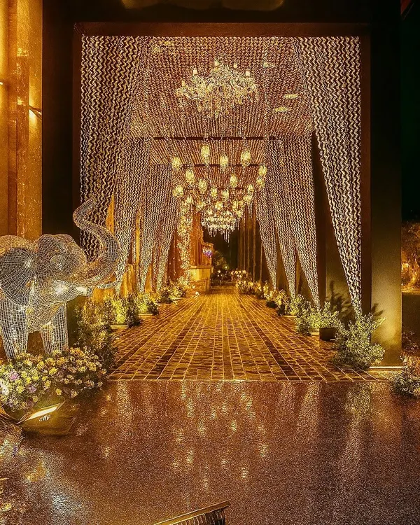 An entrance that promises a night of pure gold. We designed this spectacular golden crystal and chandelier-lined walkway to create a jaw-dropping first impression for a luxury reception.