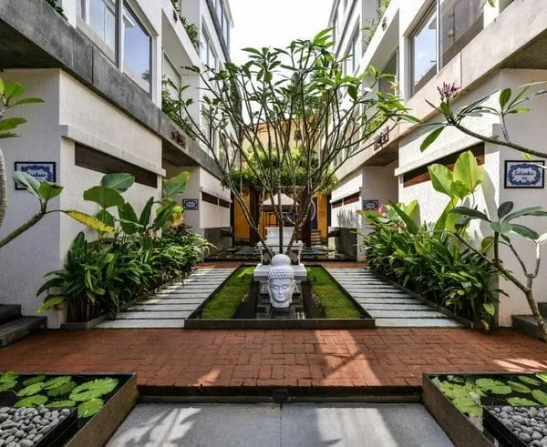 I love creating spaces that feel like a peaceful escape. For this resort courtyard, we designed a symmetrical landscape using a mix of tropical plants, brick paving, and tranquil water features with lily pads to create a truly serene environment.