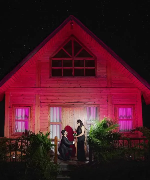We set up this magical night proposal scene in front of a rustic cabin. The dramatic red lighting and the starry sky create a highly cinematic and unforgettable image, turning a special moment into a work of art.
