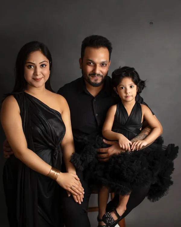 **Timeless Dark:** A classic family portrait in all black against a dark grey backdrop. This style is sophisticated, elegant, and truly timeless.