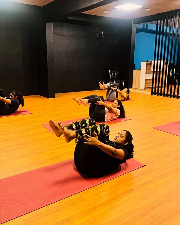 A shot from our power yoga class, with members engaging their core in a boat pose variation. These exercises are key for building a strong foundation.