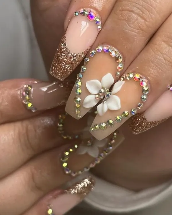 Go big or go home. This set is all about the bling, with coffin-shaped nails featuring gold glitter, 3D flowers, and a full border of iridescent rhinestones.