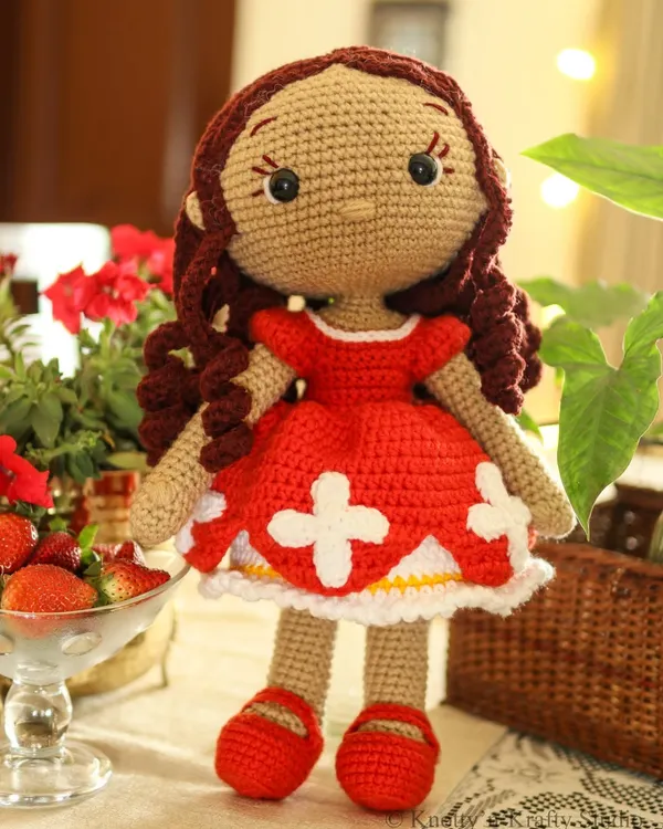 This is Lily, my first handmade doll, looking bright and cheerful in her red dress. She is designed without a smile to be a comforting friend who can share in any feeling your child has.