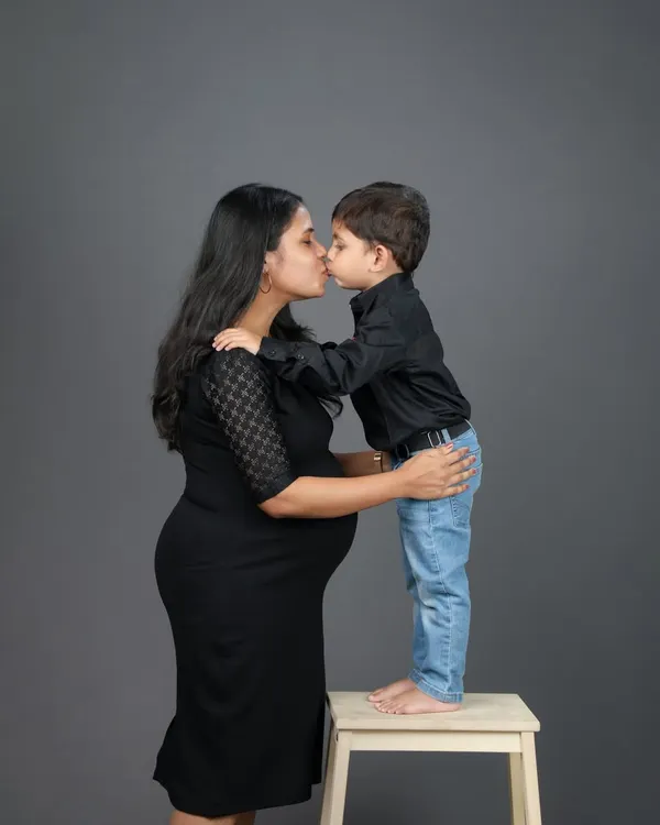 A mother's kiss for her son, while waiting for the new arrival. Maternity sessions with older siblings are so special, capturing the moment before the family grows.