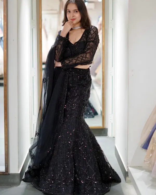 This black fish-cut lehenga is stitched with sass and main character energy. The all-over sequin work and sheer sleeves make it a glamorous choice for a cocktail night or reception.