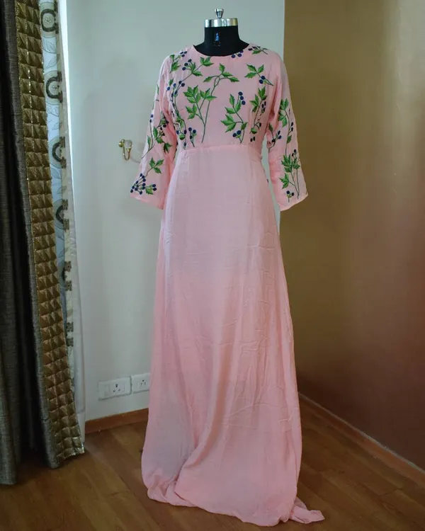 This soft pink gown is all about subtle elegance. The delicate green floral embroidery on the bodice and sleeves adds a touch of nature-inspired beauty, making it perfect for a daytime event.