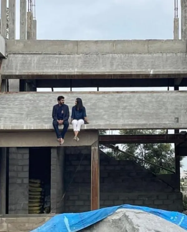 A moment of pause on site, sitting on a concrete beam of a house under construction. This is where the vision starts to take shape, and we can truly feel the scale and form of the future home.