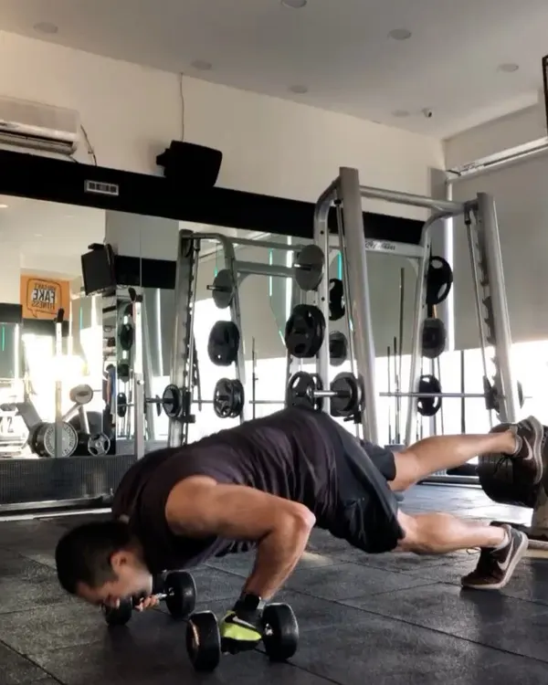 This client demonstrates a challenging dumbbell push-up, which enhances chest strength and core stability. His focus and determination during brutal workouts are always impressive.