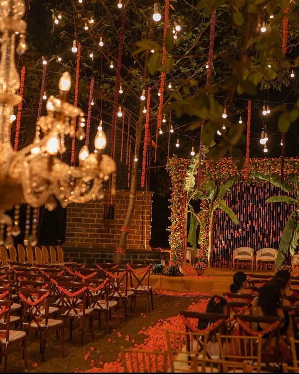 A magical mandap setting for a night ceremony. We used hundreds of marigold strings and hanging bulbs, complemented by ornate chandeliers, to create a warm, golden glow that felt both traditional and incredibly romantic.