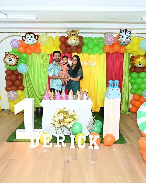 A picture-perfect first birthday. This vibrant jungle theme for Derick's party included a full backdrop, animal cutouts, custom LED name, and a matching cake table setup, with the happy family at the center of it all.