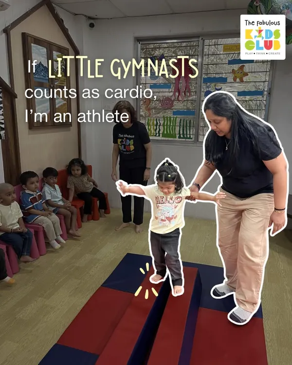 Our Little Gymnasts program is where physical development and fun come together. Here, an instructor helps a child practice her balance on the beam, building core strength and body awareness in a supportive environment.