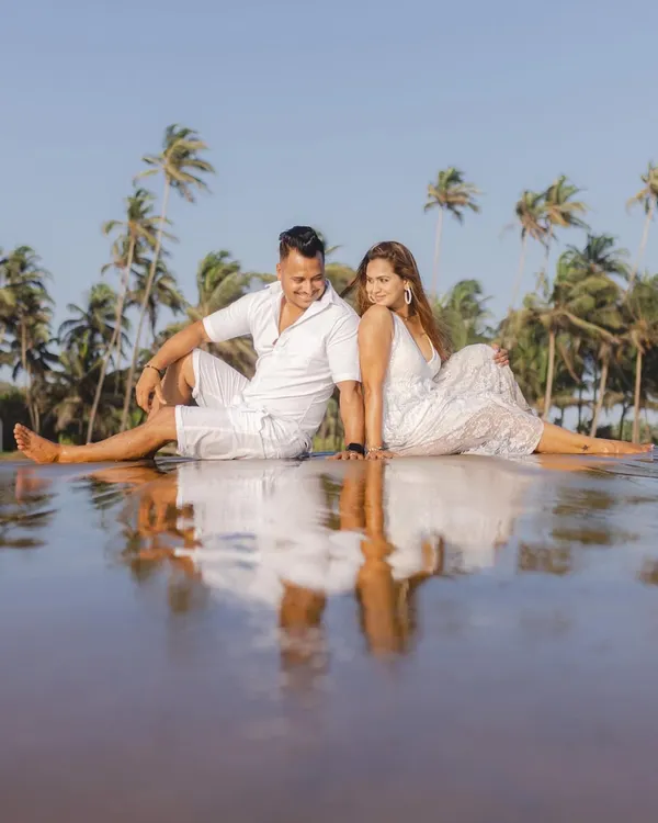 A perfect reflection. We found this spot with calm water on a Goan beach, creating a beautiful, symmetrical portrait of the couple against a backdrop of palm trees.