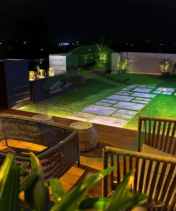 A terrace can become your private sanctuary, especially at night. We designed this space with a cozy seating area, a functional bar, and a beautiful lawn with stone pathways, all illuminated by soft lighting to create a magical ambiance.