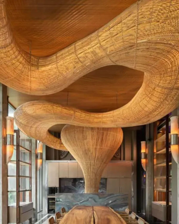 This large-scale, custom-woven rattan light installation is a centerpiece in a luxury space, demonstrating our capability to create breathtaking, architectural statements. We designed this piece to flow organically within the high-ceilinged room, creating a warm and dramatic focal point over the dining area.