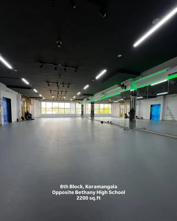 An expansive view of the empty Koramangala studio. This shot captures the sheer size of the 2200 sq.ft space, the bright, clean flooring, and the wall-to-wall mirrors, ready for you to fill with your creativity.