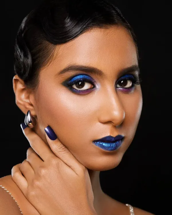A dramatic and daring look featuring a metallic blue lip and a graphic blue smokey eye. This demonstrates my ability to work with bold pigments and create a cohesive, striking look, right down to the matching nails.