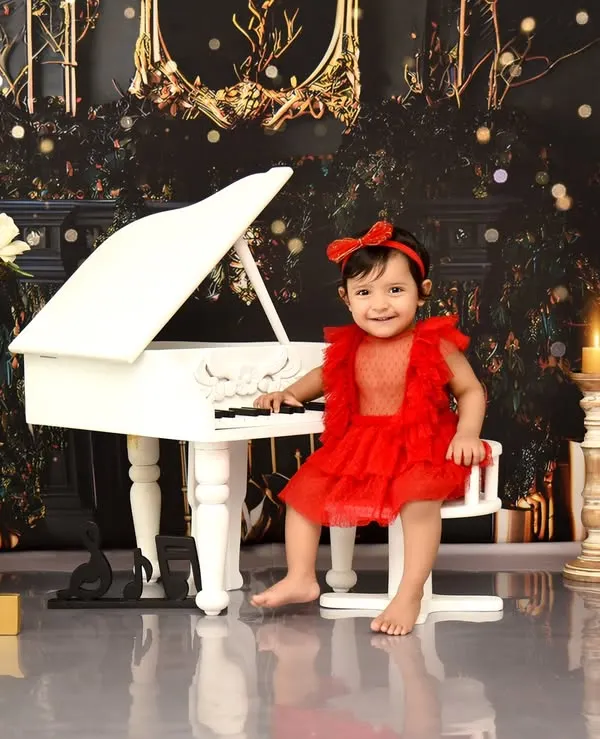 For this little musician's first birthday, we created a glamorous piano theme. I love capturing these moments of curiosity and joy as she discovers the world around her in this elegant setting.