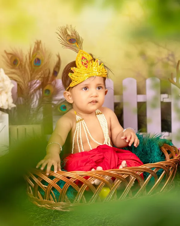 A close-up of our little Krishna, showcasing the detailed costume with a pearl necklace and peacock feather mukut (crown). These themed shoots are designed to be both beautiful and culturally significant.