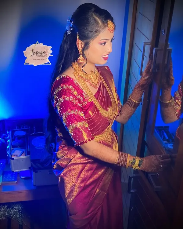 A radiant bride ready for her reception. This HD bridal look features a glossy finish and soft glam eye makeup, perfectly complementing her embroidered saree and making her glow.